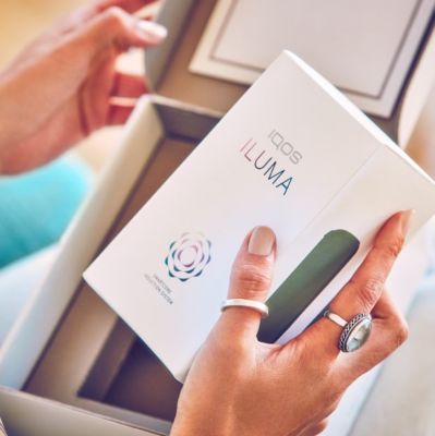 Una persona abre un Kit que contiene un IQOS ILUMA.