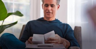A smiling woman with an IQOS ILUMA device.