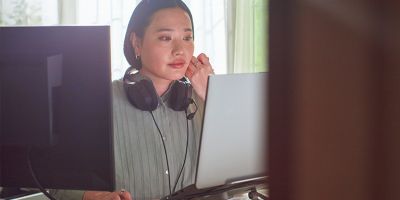 Two people holding phones over two cups of coffee.