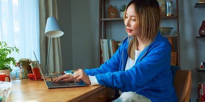 A hand showing an IQOS device to another person.