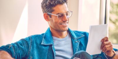 Hombre sonriendo mientras sostiene un dispositivo IQOS.