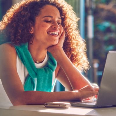 Mujer sonriendo con un IQOS ILUMA