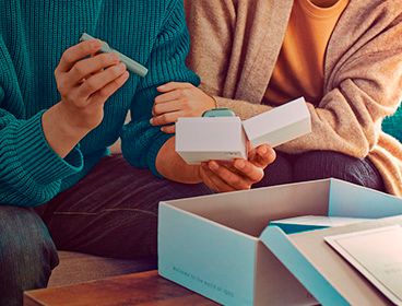 Dos personas abriendo un nuevo Kit de IQOS