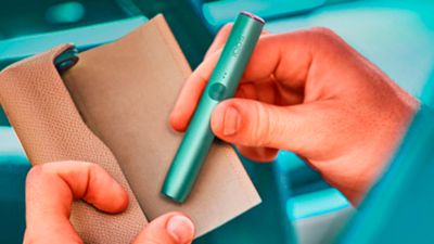 Una ilustración que muestra cómo meter el holder al cargadr del IQOS ILUMA PRIME.