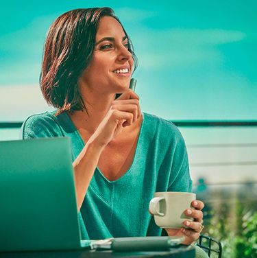 Mujer con laptop y café en mano