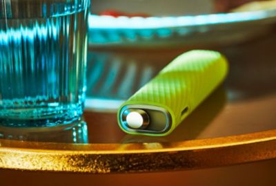 Un appareil IQOS ILUMA ONE dans la main d'une personne.