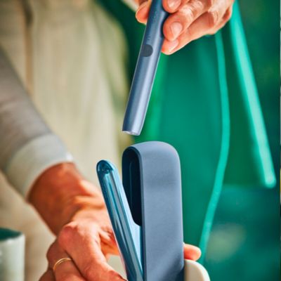 IQOS ILUMA rojo en las manos de una persona