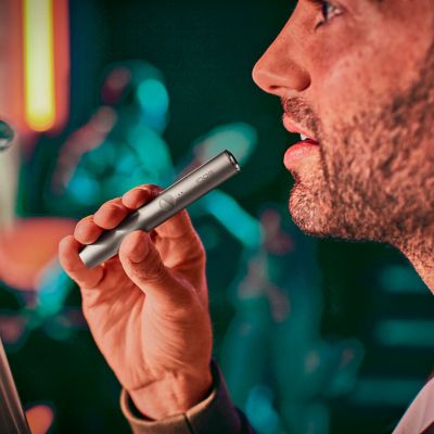 Persona sosteniendo un IQOS ILUMA gris