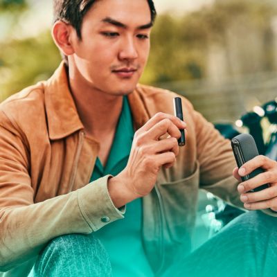 Hombre sosteniendo IQOS ILUMA negro