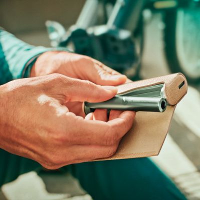 A person with a Jade Green IQOS ILUMA PRIME Holder and Pocket Charger in a full wrap