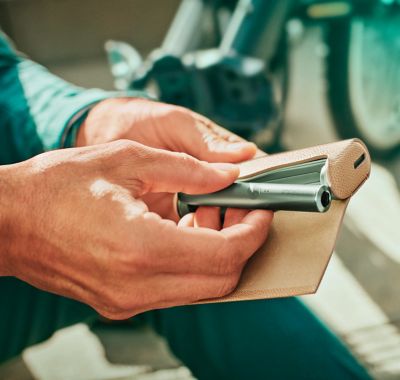 Une personne avec un support Jade Green IQOS ILUMA PRIME et un chargeur de poche dans un emballage complet.