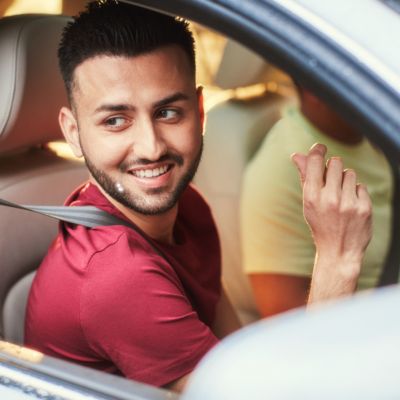 A woman wearing red holds an IQOS ILUMA ONE.