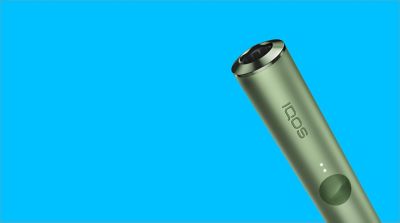 A Moss Green IQOS ILUMA with a SMARTCORE STICK inserted.
