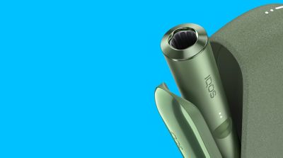 A Moss Green IQOS ILUMA device inside a pocket charger with its door open.