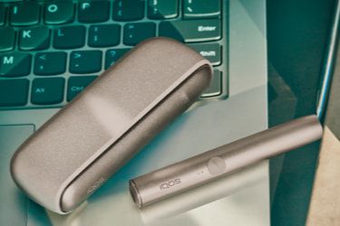 شاحن جيب جهاز IQOS IQOS ILUMA وحامله بلون بيج مُحبب.