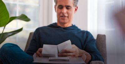 Hands opening an IQOS box. 