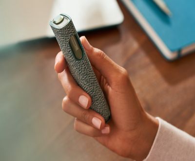 An IQOS ILUMA ONE device in a person's hand.