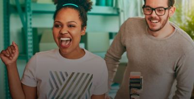 A smiling woman with an IQOS ILUMA device.