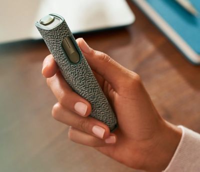 An IQOS ILUMA ONE devices in a person's hand.