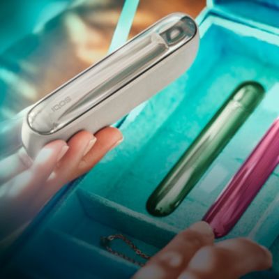 Un appareil IQOS et un chargeur sur une table.