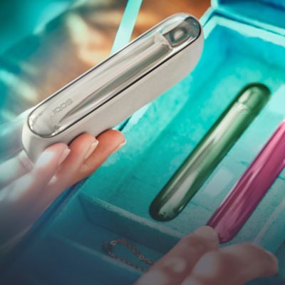 Hands comparing 3 IQOS devices.