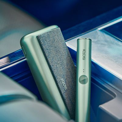 IQOS ILUMA PRIME con holder recostados dentro de un compartimiento de auto