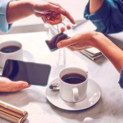 Deux personnes avec des téléphones portables prenant un café.
