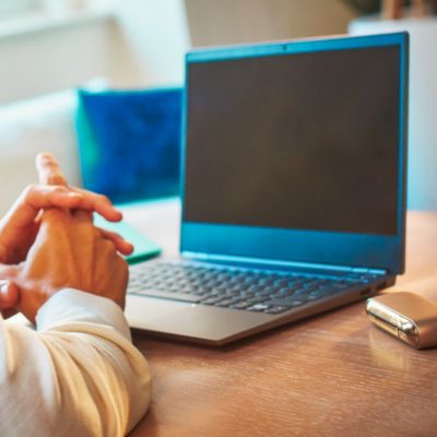 Un ordinateur portable et un appareil IQOS sur une table.