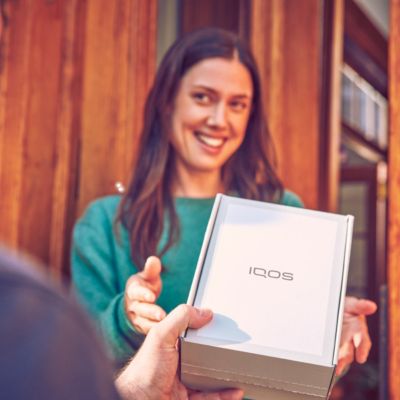 Mujer recibiendo su Kit de IQOS