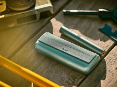 IQOS ILUMA PRIME verde encima de una mesa