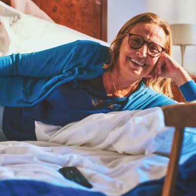 A woman in a car hoding an IQOS ILUMA ONE device. 
