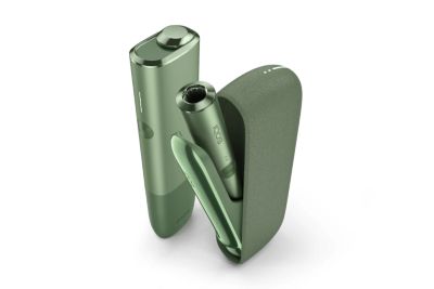 A man working on a laptop while holding an IQOS ILUMA device.