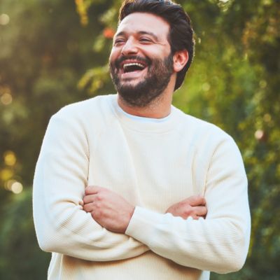 A smiling woman with an IQOS Pocket Charger and Holder.