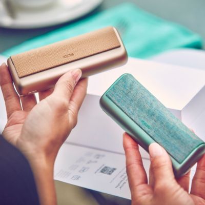 Hände halten ILUMA PRIME Golden Khaki neben ILUMA PRIME Jade Green