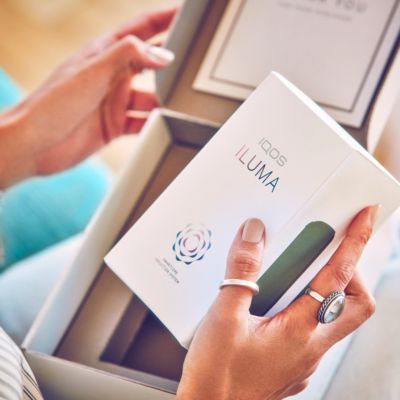 Tangan membuka kotak IQOS ILUMA