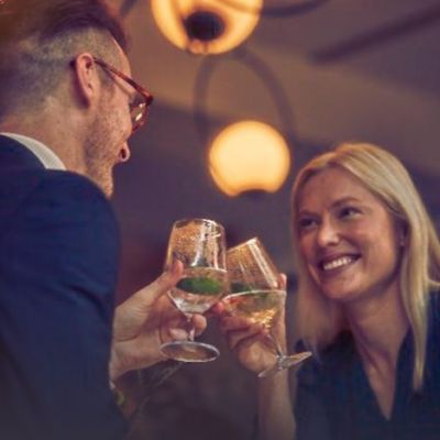 Friends raise their glasses in celebration.