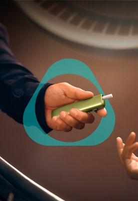 Person holding IQOS ILUMA i ONE Device with tobacco stick inserted