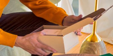 Eine Person öffnet ein IQOS Paket.