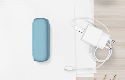 Chargeur de poche turquoise IQOS ORIGINALS DUO à côté du chargeur de câble.