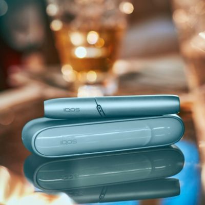 IQOS Originals Duo en turquoise sur une table basse brillante.