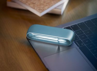 Stylet et chargeur de poche IQOS 3 DUO bleu dans un studio de musique