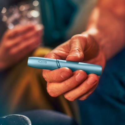 Stylet et chargeur de poche IQOS 3 DUO bleu, dans la main d'un homme