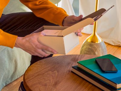 Hands opening an IQOS Originals Duo device box, to discover all benefits of MyIqos.