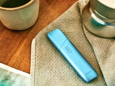 Une femme qui parle à un homme avec un IQOS 3 DUO dans la main