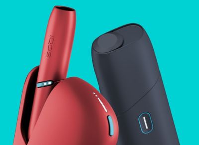Stylet IQOS 3 DUO doré et chargeur de poche dans les main d'un homme