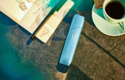 Un IQOS Originals ONE en turquoise sur une table.