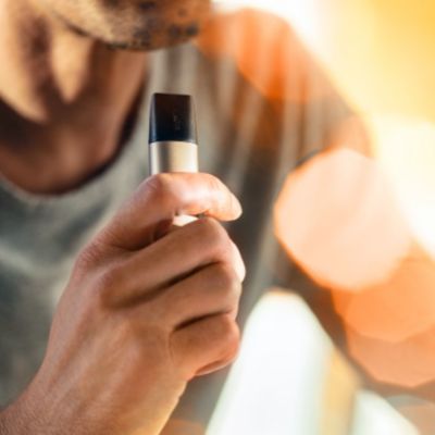 A person holding a Brilliant Gold QOS VEEV device.