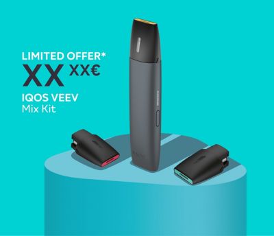 Woman holding an IQOS VEEV while looking at her mobile phone