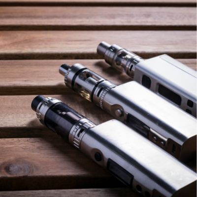 Drei verschiedene Modelle einer E-Zigarette auf einem Tisch