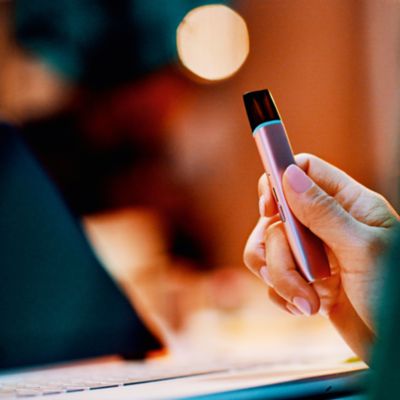 Hand hält VEEV ONE mit eingesetztem Pod